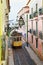 Famous tram line 28 passing a narrow street in Alfama district i