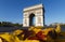 The famous Triumphal Arch and autumnal leaves in the foreground at sunny day , Paris, France