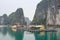 Famous UNESCO heritage site Ha Long Bay and floating village with quaint cliffs, turquoise water, boats and authentic huts