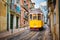 Famous vintage yellow tram 28 in the narrow streets of Alfama district in Lisbon, Portugal