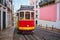 Famous vintage yellow tram 28 in the narrow streets of Alfama district in Lisbon, Portugal