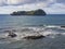 Famous volcanic islet of Vila Franca do Campo, small green crater island near sea shore with rocks ocean, blue sky and