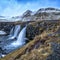 Famous waterfall Kirkjufellsfoss under the conical mountain Kirkjufells