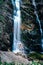 Famous waterfalls below the alpine mountain Hochkar called Wasserlochklamm. A half-naked man poses in front of the largest