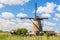 Famous windmills in Kinderdijk village in Holland. Colorful spring rural landscape with windmill and blue cloudy sky in Netherland