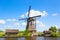 Famous windmills in Kinderdijk village in Holland. Colorful spring rural landscape with windmill and blue cloudy sky in Netherland