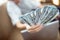 A fan of hundred-dollar bills in the hands of a teenager. The student earned money to study at the university. Luck. Money won