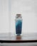 Fancy bottle with blue bath salts for relaxing spa treatments with white background