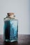 Fancy bottle with blue bath salts for relaxing spa treatments with white background