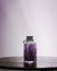 Fancy bottle with lavender purple bath salts for relaxing spa treatments with white background