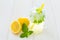 Fancy cool glass of lemonade with ice and mint, Mason jar style cup with yellow straw, green leaves of fresh mint and lemons, one