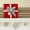 Fancy red and silver Christmas gift present on living room mantel with glitter snowflake garland. Beautiful, elegant holiday home