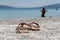Fancy sandals on sand of Lake Salda and blurred woman in background, Burdur, Turkey