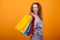 Fancy woman smiling and holding colorful shopping bags
