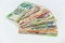 Fanned colorful international money bills on white background