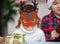 Fanny kids girl in deer mask and boy in Santa cap holding a cone and gift box in a hands