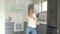 Fanny video portrait of a beautiful young woman dancing in her new kitchen after the repair is completed. Real estate