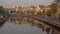 Fantastic Amsterdam canals with typical houses at sunrise in summer. Windmill and lifting bridges