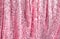 Fantastic background glitters pink curtain made of luxurious lurex sequins. Festive podium for party or Christmas.