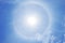 A fantastic circular Halo around the Sun , Natural light phenomena around the Sun with blue sky and clouds