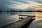 Fantastic cloud bands on the sky and a wooden fishing pier