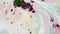 Fantastic, colorful background of dry inks floating on the surface of liquid white substance, top view. Green and purple