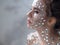 Fantastic fashion portrait of a young beautiful woman with transparent crystals on her face and shoulders.