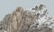 Fantastic fictional rock or mountain in white hues with sun glares over light gray sky.