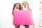 Fantastic information. Little girls holding blank paper sheet for information on white background. Small kids with blank