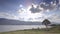 Fantastic landscape with lake, tree, and mountain. Overcast sky.