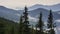 Fantastic mountain landscape and clouds moving in the valley with pine tree forests. Time lapse.