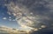 Fantastic panorama view of bright white gray dark wide puffy clouds lit by sun spreading against deep blue sky moving with wind.