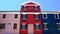 Fantastic pink, red and blue houses decorated with nice flowers, Burano island