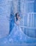 Fantastic snow queen in a luxurious dress, in an ice room. The interior fills with magic, her dress sparkles and glows