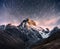 Fantastic starry sky. Snow-capped peaks. Main Caucasian Ridge. Mountain View from Mount Ushba Meyer, Georgia. Europe