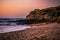 Fantastic sunset in the landscape, with cliff and rocks and surfer walking along the sea on the beach of SÃ£o LourenÃ§o, Ericeira