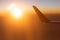Fantastic time, scenic view from airplane window seat, the sun setting on gently clouds and skyline. The wing of the plane in the