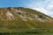 Fantastic view from below of the hill and clouds on a summer\\\'s day. Grass and many stones grow on hill