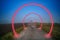 Fantastic view of a country road in the fog and red rings of space portals
