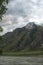 Fantastic volcano with steam clouds and a mountain stream at the