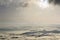 Fantastic wide top view of mountain valley filled with white puffy like snow clouds and fog stretching to horizon under bright mo