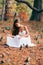 Fantastic young woman. beautiful fantasy girl fairy with white long dress in windy autumn park