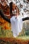 Fantastic young woman. beautiful fantasy girl fairy with white long dress in windy autumn park