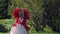 fantasy image of red queen, blonde woman in red gorgeous dress is walking in garden