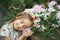 Fantasy little girl with rainbow unicorn horn with flowers in azalea park