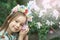 Fantasy little girl with rainbow unicorn horn with flowers in azalea park