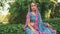 fantasy woman sits on green grass ivy, enjoy summer green nature, tropical garden park. National India blue pink dress