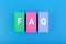 FAQ concept. Faq letters written on multicolored rectangles on blue background
