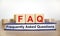 FAQ frequently asked questions symbol. Concept words `FAQ frequently asked questions` on wooden cubes on book on a beautiful whi