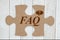 FAQ message on brown cardboard puzzle piece